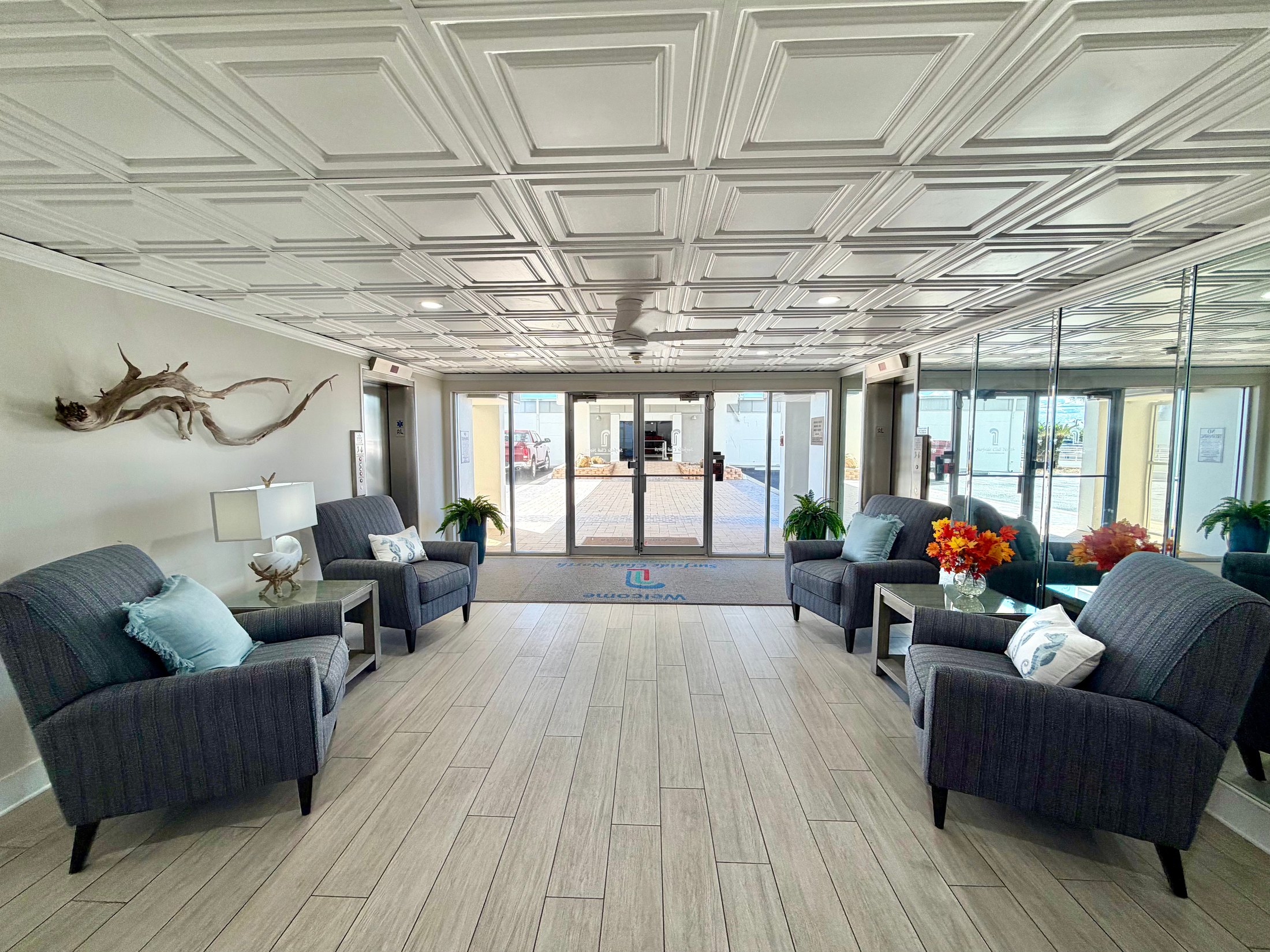 Surfside Club North lobby with seating, elevators and mirrored wall